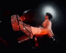 a woman is sitting at a piano with her feet up