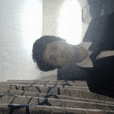 a man in a suit and tie is standing on a staircase