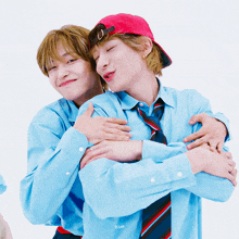 two boys hugging each other with one wearing a blue shirt with blue written on it