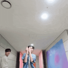 a person covering their face with their hands while wearing a denim jacket