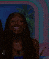 a woman with long hair is laughing and smiling in front of a palm tree .