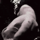 a close up of a person holding a glass in their hand in a black and white photo .