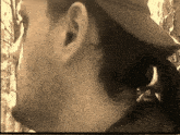 a close up of a man 's ear and neck with a hat on