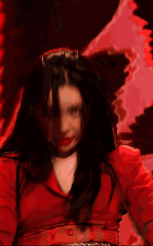 a woman in a red jacket is dancing in a dark room