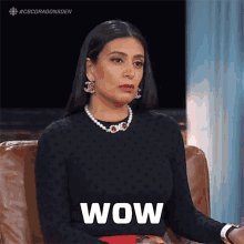 a woman is sitting in a chair with the word wow written on her chest