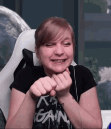 a woman wearing a black shirt that says it 's gain on it