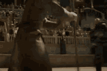 two men are fighting with swords in a desert