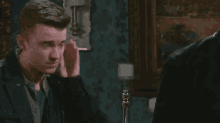 a man in a blue jacket is talking to another man in a suit .