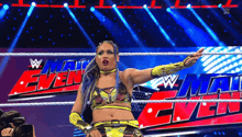 a female wrestler is standing in a wrestling ring with a sign that says w mat even