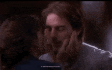 a woman is kissing a man on the cheek in a movie scene .