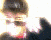 a blurry image of a person 's face with sunglasses on