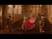 a woman in a long red dress is standing on stairs