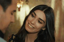a woman is smiling and looking at a man .
