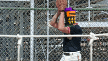 a baseball player is wearing a purple and orange cube on his head