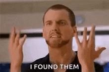 a man is making a funny face and saying `` i found them '' .