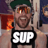 a shirtless man wearing sunglasses and a hat with the word sup on it