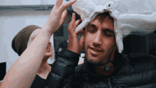 a man with a helmet on his head is being held by a woman
