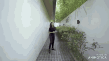 a woman is standing in a hallway with a sign that says made in animotica