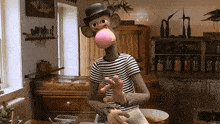 a cartoon monkey blowing a pink bubble with his mouth