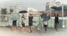 a group of people are holding umbrellas and a ball