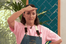 a woman is wearing an apron that says bake off on it