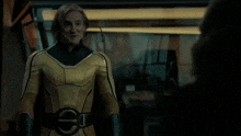 a man in a yellow superhero costume with a belt that has a euro symbol on it