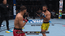 two men are fighting in a boxing ring with the ufc logo on the wall behind them