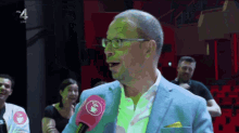 a man wearing glasses is talking into a pink microphone with the letters rtl on the bottom