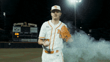 a baseball player stands in front of a scoreboard that says claude smith fields