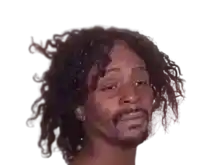 a man with curly hair and a beard looks at the camera with his eyes closed