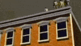 a group of people standing on the roof of a brick building .