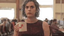 a woman with blue hair is holding a cup with an arrow pointing up