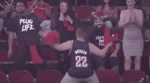 a man is dancing in front of a crowd of people in a basketball stadium .