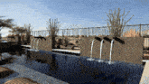 a fence surrounds a swimming pool with a waterfall