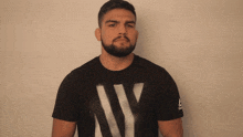 a man with a beard is wearing a black t-shirt that says ny