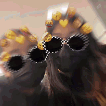 a girl wearing sunglasses with emojis on her face and a sticker that says asian