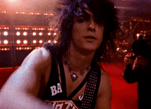 a man wearing a black tank top with ba on the front