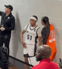 a basketball player wearing a number 51 jersey talks to another player