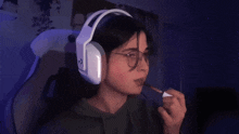 a person wearing headphones is applying lipstick to their lips