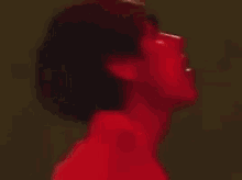 a blurry picture of a person 's face with a red light shining on it .