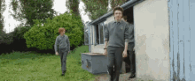 a group of boys in school uniforms are walking out of a shed