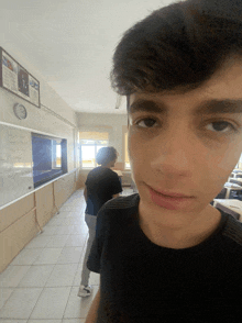 a boy with a bandage on his face stands in a hallway