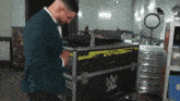 a man in a suit is standing in front of a case with a w logo on it