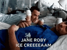 a man in a hospital bed is holding an ice cream cone next to another man .
