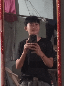 a young man takes a selfie in front of a mirror