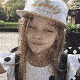 a little girl wears a hat that says lovely little girl