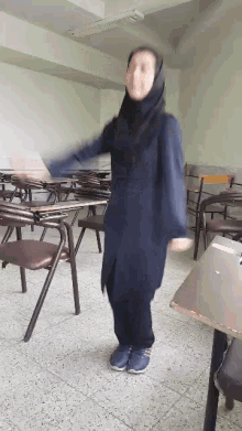 a woman is dancing in a classroom with chairs .