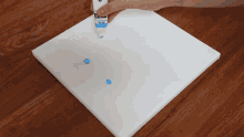 a person is holding a tube of blue paint