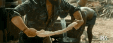 a man with a beard is holding a long piece of rope .