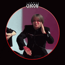a man in a black jacket is sitting in a red circle with the word choom on it